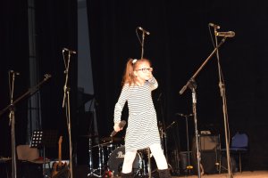 na scenie śpiewa mała dziewczynka