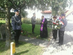 policjanci, ksiądz i kobieta przy pomniku