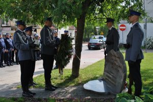 policjanci przy pomniku składają wieniec i znicze