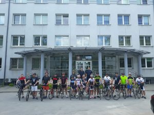 zdjęcie grupowe rowerzystów i policjantów przed budynkiem kwp w olsztynie