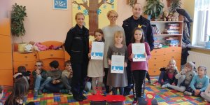 policjantka, policjant, nauczycielka, trzy zwyciężczynie stoją, na podłodze siedzą dzieci