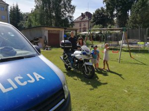 radiowóz, motocykl policyjny, policjant i dzieci