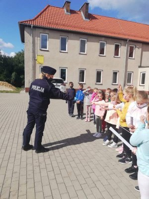 policjantka przekazuje dzieciom odblaski