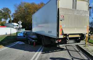 na drodze w poprzek jezdni stoi pojazd ciężarowy Iveco a przy nim pojazd BMW. Przód pojazdu BMW uderzył w podwozie samochodu Iveco