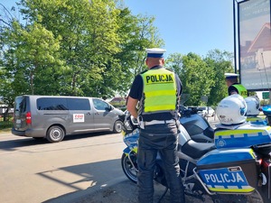policjant ruchu drogowego stojący przy motocyklu