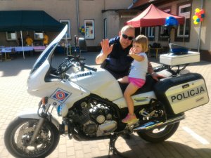 policjant z dzieckiem na policyjnym motocyklu